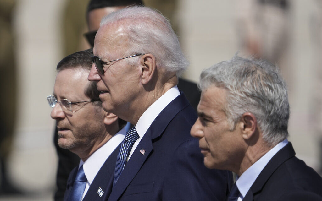 President Joe Biden, center, Israeli President Isaac Herzog, left, and Israeli Prime Minister Yair Lapid, walk during a welcoming ceremony after Biden arrived at Ben Gurion Airport, near Tel Aviv, Israel, Wednesday, July 13, 2022. (AP Photo/Ariel Schalit)