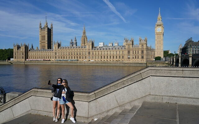 Two people take a selfie opposite the Houses of Parliament in London, Friday July 15, 2022. The British Meteorologic office issued a red warning for extreme heat, advising of a 'potentially very serious situation' in parts of England next week. (Dominic Lipinski/PA via AP) Two people take a selfie opposite the Houses of Parliament in London, Friday July 15, 2022. The British Meteorologic office issued a red warning for extreme heat, advising of a 'potentially very serious situation' in parts of England next week. (Dominic Lipinski/PA via AP)