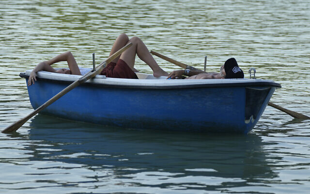 People relax on a pleasure boat on the lake in the Retiro park in Madrid, Spain, July 16, 2022 (AP Photo/Paul White) People relax on a pleasure boat on the lake in the Retiro park in Madrid, Spain, July 16, 2022 (AP Photo/Paul White)