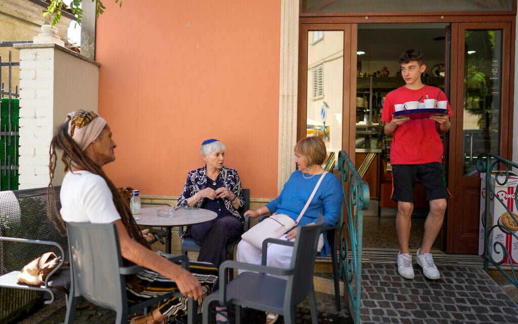Rabbi Barbara Aiello, second from left, talks with Lidia as they sit at a caffe' in Serrastretta, southern Italy, July 8, 2022 (AP Photo/Andrew Medichini)