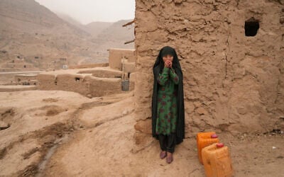 FILE - An Afghan girl warms up her hands as she is resting from carrying the water in Balucha, Afghanistan, Dec. 14, 2021. The Middle East is one of the most vulnerable regions in the world to the impact of climate change, and already the effects are being seen. This year's annual U.N. climate change conference, known as COP27, is being held in Egypt in November 2022, throwing a spotlight on the region. (AP Photo/Mstyslav Chernov) FILE - An Afghan girl warms up her hands as she is resting from carrying the water in Balucha, Afghanistan, Dec. 14, 2021. The Middle East is one of the most vulnerable regions in the world to the impact of climate change, and already the effects are being seen. This year's annual U.N. climate change conference, known as COP27, is being held in Egypt in November 2022, throwing a spotlight on the region. (AP Photo/Mstyslav Chernov)