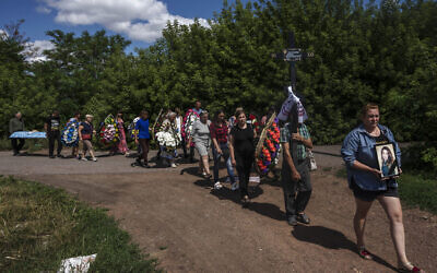 Family and friends of 35-year-old Anna Protsenko, who was killed in a Russian rocket attack, walk to a cemetery for her burial, during her funeral procession, on the outskirts of Pokrovsk, eastern Ukraine, July 18, 2022. (Nariman El-Mofty/AP) Family and friends of 35-year-old Anna Protsenko, who was killed in a Russian rocket attack, walk to a cemetery for her burial, during her funeral procession, on the outskirts of Pokrovsk, eastern Ukraine, July 18, 2022. (Nariman El-Mofty/AP)