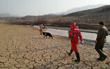 In this photo provided by the Iranian Red Crescent Society on July 23, 2022, members of a rescue team search for missing people of flash floods in Iran's drought-stricken southern Fars province, Iran. (Iranian Red Crescent Society via AP)