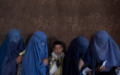 Afghan women wait to receive cash at a money distribution point organized by the World Food Program, in Kabul, Afghanistan, on Nov. 20, 2021 (AP Photo/Petros Giannakouris, File)