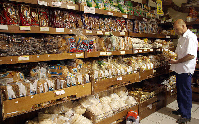 Illustrative: A man shops for bread in a supermarket in Jerusalem. (Orel Cohen/Flash90)