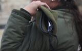 Illustrative: An IDF soldier places a beret on her shoulder in the Old City of Jerusalem. January 11, 2016. (Esther Rubyan/ Flash90/ File)