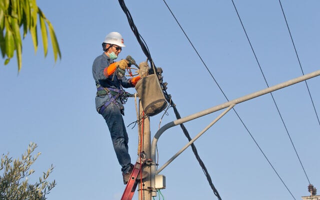 A worker from the Israel Electric Corporation is seen repairing a faulty line, August 29, 2020. (Yossi Aloni/FLASH90) A worker from the Israel Electric Corporation is seen repairing a faulty line, August 29, 2020. (Yossi Aloni/FLASH90)