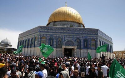 People hold Hamas flags as Palestinians gather at the Temple Mount in the Old City of Jerusalem, May 7, 2021. (Jamal Awad/Flash90)