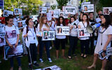 Demonstrators hold signs with images of women who have been killed as they protest against violence against women, in Tel Aviv on June 25, 2022 (Tomer Neuberg/FLASH90)