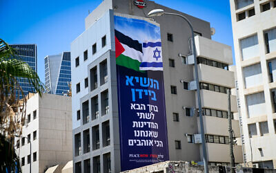A banner that includes an Israeli flag and a Palestinian flag, as part of a campaign by left-wing group Peace Now, in the lead up to US President Joe Biden's official visit, on display in Tel Aviv, July 11, 2022. 'President Biden, welcome to the two states we love the most,' it reads. (Avshalom Sassoni/Flash90)