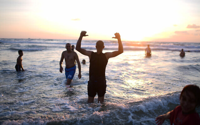 Muslims enjoy the sea by Tel Aviv during the third day of Eid al-Adha, on July 11, 2022. (Tomer Neuberg/Flash90) Muslims enjoy the sea by Tel Aviv during the third day of Eid al-Adha, on July 11, 2022. (Tomer Neuberg/Flash90)