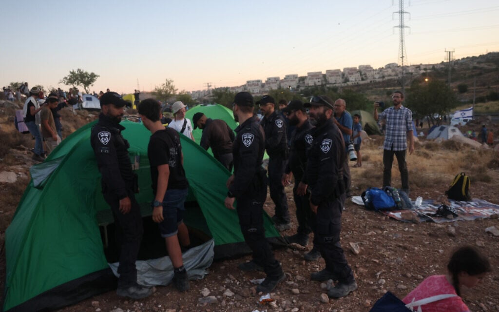 Settlers set up tents in an effort to establish a new illegal outpost near Kiryat Arba, July 20, 2022. (Yonatan Sindel/FLASH90) Settlers set up tents in an effort to establish a new illegal outpost near Kiryat Arba, July 20, 2022. (Yonatan Sindel/FLASH90)