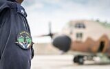 An Israeli Air Force pilot is seen next to a C-130 transport aircraft in Romania, July 4, 2022. (Israel Defense Forces)