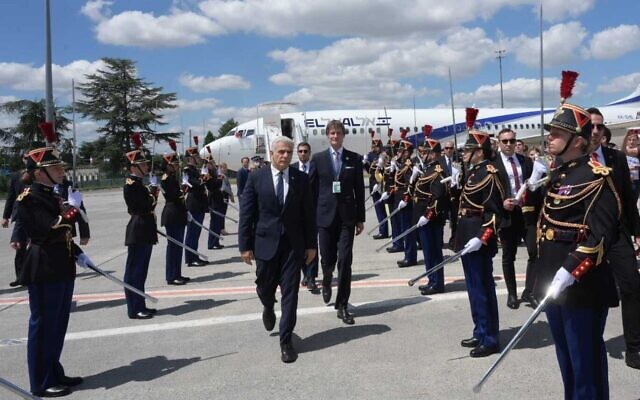 Prime Minister Yair Lapid, center, is greeted at Charles De Gaulle airport in Paris, France, on July 5, 2022. (Amos Ben Gershom/GPO) Prime Minister Yair Lapid, center, is greeted at Charles De Gaulle airport in Paris, France, on July 5, 2022. (Amos Ben Gershom/GPO)