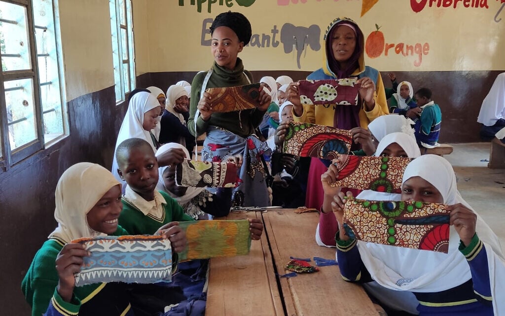 Teachers and students show off the sanitary napkins they have sewn in Malindi, Tanzania, May 2022 (Courtesy of Afrikan)