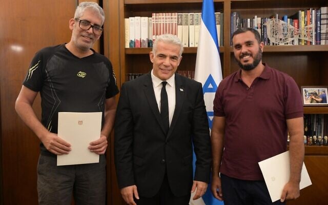 Prime Minister Yair Lapid (center) meets with Haim Naim (right) and Meshi Ben Ami at his office in Jerusalem, July 20, 2022. (Amos Ben-Gershom/GPO) Prime Minister Yair Lapid (center) meets with Haim Naim (right) and Meshi Ben Ami at his office in Jerusalem, July 20, 2022. (Amos Ben-Gershom/GPO)