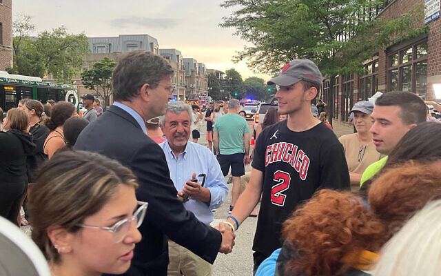 Rep. Brad Schneider, left, chats with a constituent two days after a mass shooting, in Highland Park, Ill., July 6, 2022. (Twitter via JTA) Rep. Brad Schneider, left, chats with a constituent two days after a mass shooting, in Highland Park, Ill., July 6, 2022. (Twitter via JTA)