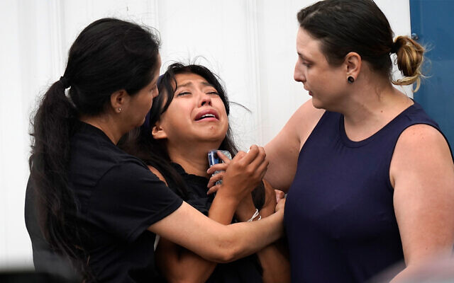 Yesenia Hernandez, center, granddaughter to Nicolas Toledo-Zaragoza, who was killed during a Fourth of July parade earlier in the week in Highland Park., Ill., is comforted outside the Iglesia Emanuel Church during a private family viewing before the funeral service, July 8, 2022, in Waukegan, Ill. (AP Photo/Charles Rex Arbogast) Yesenia Hernandez, center, granddaughter to Nicolas Toledo-Zaragoza, who was killed during a Fourth of July parade earlier in the week in Highland Park., Ill., is comforted outside the Iglesia Emanuel Church during a private family viewing before the funeral service, July 8, 2022, in Waukegan, Ill. (AP Photo/Charles Rex Arbogast)