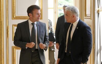 France's President Emmanuel Macron (L) and Prime Minister Yair Lapid speak at the Elysee Palace in Paris, July 5, 2022 (Amos Ben Gershom/GPO)