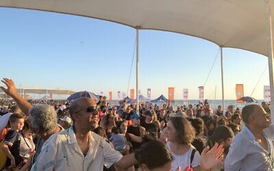 Visitors attend a concert by the band Teapacks at the Maccabiah Village on Netanya's Poleg beach on July 19, 2022. (Charlie Summers/Times of Israel)