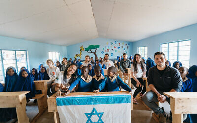 Members of the first Afrikan delegation sit with students in a renovated classroom in a school in Malindi, Tanzania, in May 2021.(Idan Arad/Courtesy of Afrikan)