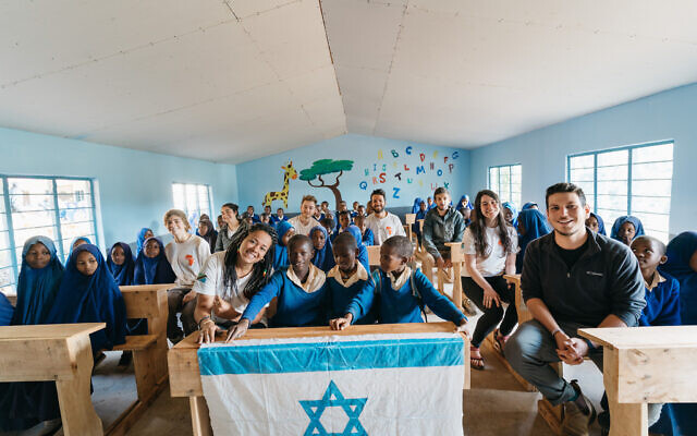 Members of the first Afrikan delegation sit with students in a renovated classroom in a school in Malindi, Tanzania, in May 2021.(Idan Arad/Courtesy of Afrikan)