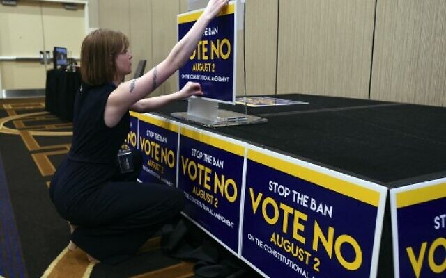 Field organizer Jae Grey places signs on the podium before the pro-choice Kansas for Constitutional Freedom primary election watch party in Overland Park, Kansas, August 2, 2022. (Dave Kaup/AFP)