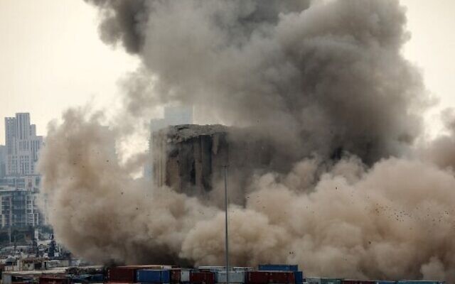 Heavy dust rises as part of the grain silos in the port of Beirut collapse on the 2nd anniversary of a deadly blast which killed over 200 people, August 4, 2022. (Ibrahim Amro/AFP) Heavy dust rises as part of the grain silos in the port of Beirut collapse on the 2nd anniversary of a deadly blast which killed over 200 people, August 4, 2022. (Ibrahim Amro/AFP)
