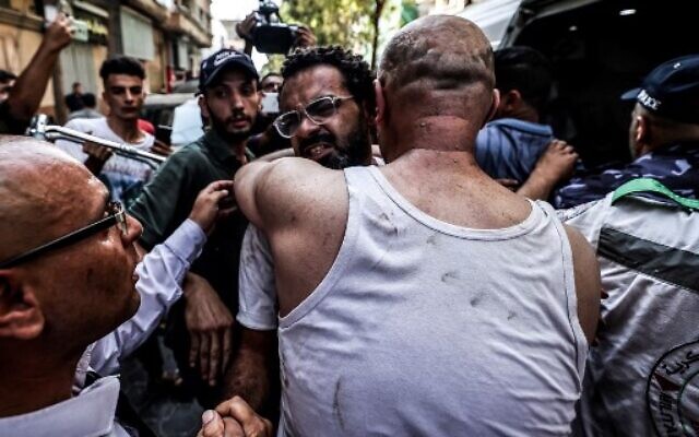 A Palestinian man is comforted by others as he reacts following an Israeli airstrike on Gaza City, on August 5, 2022. (MAHMUD HAMS / AFP) A Palestinian man is comforted by others as he reacts following an Israeli airstrike on Gaza City, on August 5, 2022. (MAHMUD HAMS / AFP)