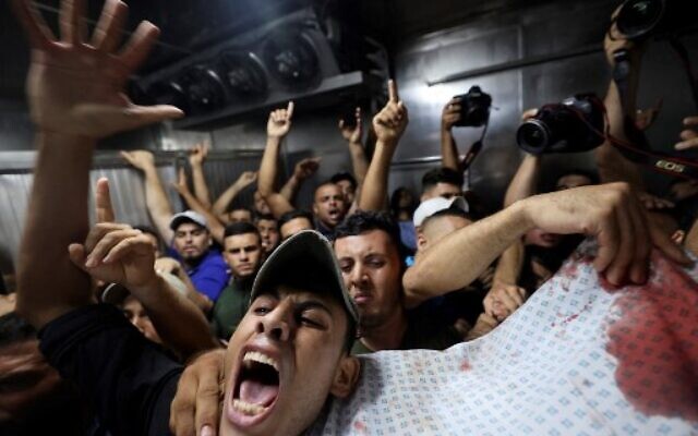 Palestinians react as they remove the corpse of one of the victims of an Israeli air strike on Gaza City, from the morgue of the Shifa hospital, on August 5, 2022. (MOHAMMED ABED / AFP) Palestinians react as they remove the corpse of one of the victims of an Israeli air strike on Gaza City, from the morgue of the Shifa hospital, on August 5, 2022. (MOHAMMED ABED / AFP)