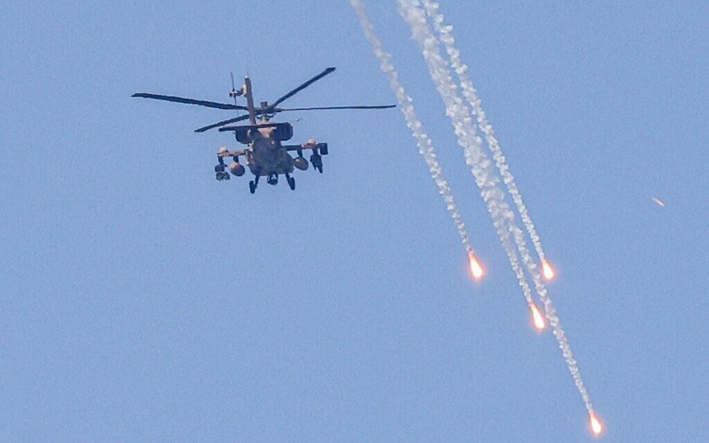 An Israeli military AH-64 Apache attack helicopter fires flares while flying over Ashkelon in southern Israel on August 6, 2022. (Jack Guez/AFP)