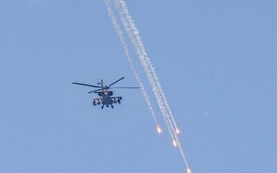 An Israeli military AH-64 Apache attack helicopter fires flares while flying over Ashkelon in southern Israel on August 6, 2022 (Jack Guez / AFP)