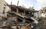 Palestinians salvage belongings from the rubble of their home, following Israeli air strikes in Gaza City, on August 7, 2022. Israel says it is conducting strikes on terror targets while terror groups fire rockets at Israel. (Mahmud Hams/AFP)