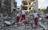 Rescuers walk in the rubble of a building following Israeli airstrikes in Rafah in the southern Gaza Strip, on August 7, 2022, amid fighting between the Israel Defense Forces and Palestinian Islamic Jihad terror group. (Said Khatib/AFP)