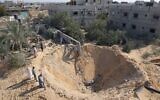 Palestinians inspect a crater following three days of conflict with Israel ahead of a truce, in Rafah town in the southern Gaza Strip, on August 8, 2022. (SAID KHATIB / AFP)