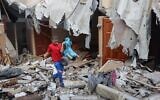 A Palestinian youth salvages a toy from the rubble of his house which was destroyed during the latest three days of conflict with Israel ahead of a truce, in Rafah town in the southern Gaza Strip, on August 8, 2022. (SAID KHATIB / AFP)
