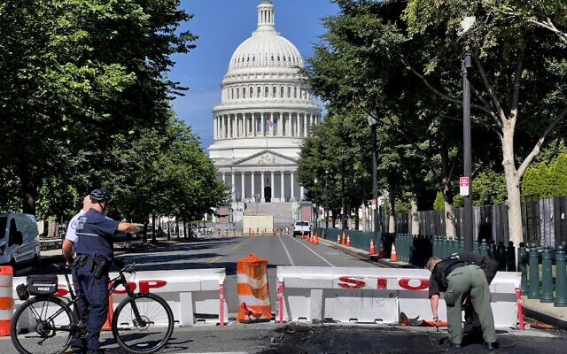 US Capitol Police officers work near a police barricade on Capitol Hill in Washington, DC, on August 14, 2022.(Daniel SLIM / AFP) US Capitol Police officers work near a police barricade on Capitol Hill in Washington, DC, on August 14, 2022.(Daniel SLIM / AFP)