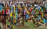 People attend a ceremony for the fallen soldiers of Ukraine at the Lychakiv Cemetery in western Ukrainian city of Lviv on August 24, 2022 (YURIY DYACHYSHYN/AFP)