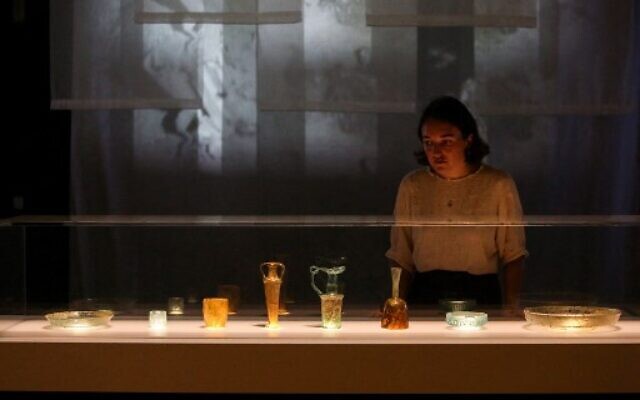 British museum press assistant Stella Scobie examines the newly conserved ancient glass vessels damaged during the 2020 Beirut port explosion, and displayed at the British Museum in London, on August 24, 2022 (Susannah Ireland/AFP) British museum press assistant Stella Scobie examines the newly conserved ancient glass vessels damaged during the 2020 Beirut port explosion, and displayed at the British Museum in London, on August 24, 2022 (Susannah Ireland/AFP)