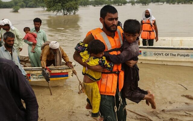 Rescue workers help evacuate flood affected Pakistanis from their flood hit homes following heavy monsoon rains in Rajanpur district of Punjab province on August 27, 2022. (Shahid Saeed Mirza/AFP) Rescue workers help evacuate flood affected Pakistanis from their flood hit homes following heavy monsoon rains in Rajanpur district of Punjab province on August 27, 2022. (Shahid Saeed Mirza/AFP)