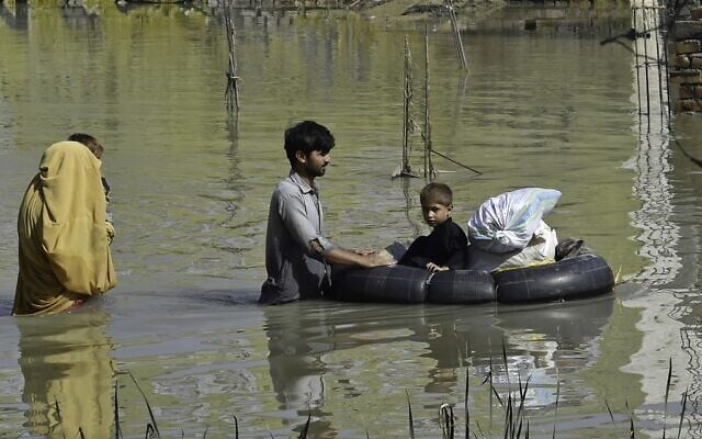 A family wades through a flood hit area following heavy monsoon rains in Charsadda district of Khyber Pakhtunkhwa on August 29, 2022 (Abdul MAJEED / AFP) A family wades through a flood hit area following heavy monsoon rains in Charsadda district of Khyber Pakhtunkhwa on August 29, 2022 (Abdul MAJEED / AFP)