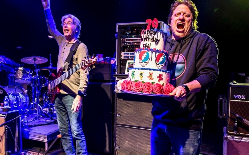 Peter Shapiro, right, brings out a birthday cake to Phil Lesh, who turned 79 on the evening of his 79th performance at the Capitol Theatre. (Jay Blakesberg/ Courtesy)