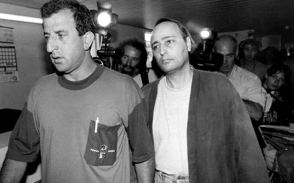 Eddie Antar, right, once known as 'Crazy Eddie,' New York's electronics king, is led by an Israeli police detective in Petah Tikva, Israel, June 25, 1992. (Sven Nackstrand/AFP via Getty Images/ via JTA)