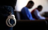 Illustrative: A Kurdish security officer, foreground, stands guard next to Alexanda Amon Kotey, center, and El Shafee Elsheikh, right, two British alleged members of an Islamic State cell dubbed "The Beatles," known for beheading hostages in northern Syria, during an interview with The Associated Press, at a security center, in Kobani, Syria, March 30, 2018. (AP Photo/Hussein Malla)