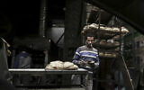 A vendor counts his money at a bread stand in the Sayeda Zeinab neighborhood of Cairo, Egypt, February 14, 2017 (AP/Nariman El-Mofty)