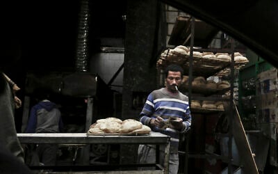 A vendor counts his money at a bread stand in the Sayeda Zeinab neighborhood of Cairo, Egypt, February 14, 2017 (AP/Nariman El-Mofty)