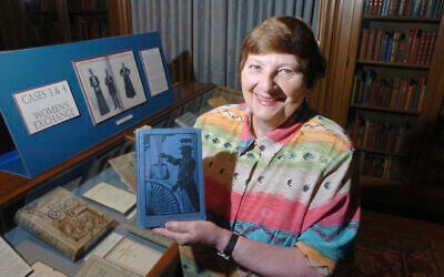 Janice Longone, Curator of American Culinary History, holds up a book from the exhibit titled "The Old Girl Network: Charity Cook Books and the Empowerment of Women" at the University of Michigan Clements Library in Ann Arbor, Michigan, September 5, 2008. (Alan Warren/Ann Arbor News via AP)