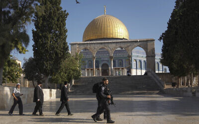 Israeli police officers escort a group of Jewish men to visit the Temple Mount, August 7, 2022. (AP Photo/Mahmoud Illean)