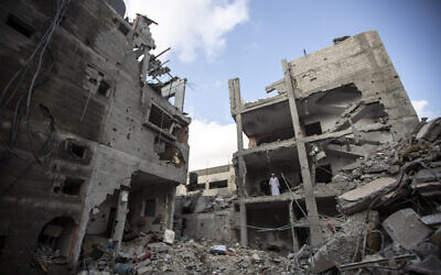 Palestinians search through the rubble of a building in which Khaled Mansour, a top Islamic Jihad terror commander was killed in an Israeli airstrike in Rafah, southern Gaza Strip, August 7, 2022  (AP Photo/Yousef Masoud)