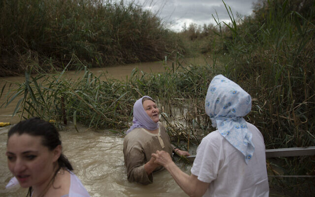 Christian pilgrims stand in the waters of the Jordan River during a baptism ceremony as part of the Orthodox Feast of the Epiphany at the Qasr al-Yahud baptismal site, near the West Bank town of Jericho,  Jan. 19, 2018. (Oded Balilty/AP)